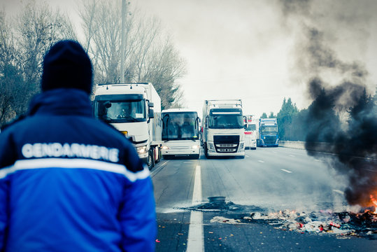 camion bloqu&eacute;s sur autouroute- de dos un gendarme face aux camions
