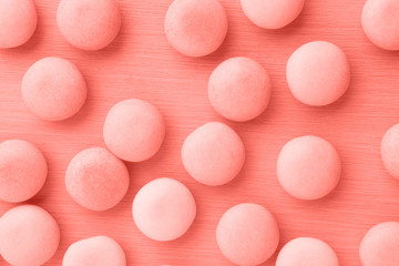 Small round candy living coral pastel background.