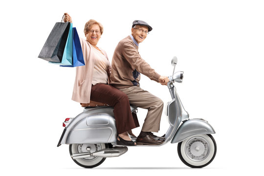 Senior Couple With Shopping Bags On A Vintage Scooter