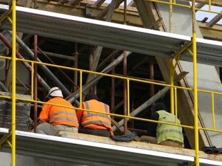Construction workers taking a break on the scaffolding of a residential construction site, Tirana, Albania
