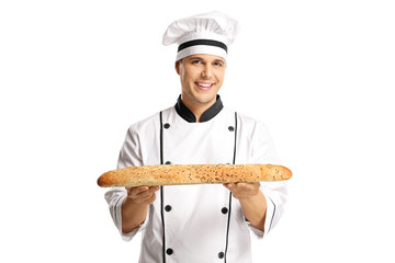Young male baker holding a freshly baked baguette bread