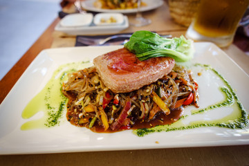 Delicious medium tuna steak with vegetables and asian sauce
