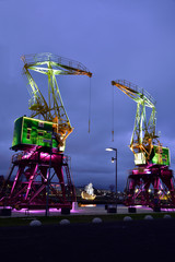 Colorfully illuminated antique cranes on the quay of Szczecin Łasztownia.