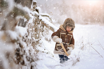 Child in winter. Fun little boy in the snow. The child is playing outside. Winter background....