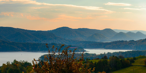 Fototapeta premium Polanczyk, Bieszczady Mountains, Poland: Sun rising over mountains. Views from near hill. In background Solina Lake.