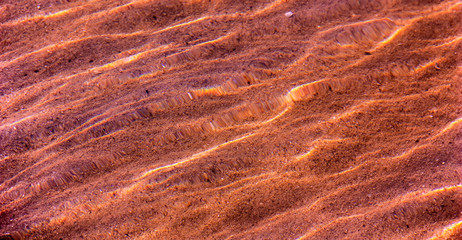 The texture of the sand on the bottom through the water