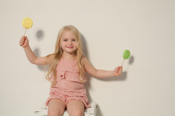 little girl eating sweet candy lollipop on a stick