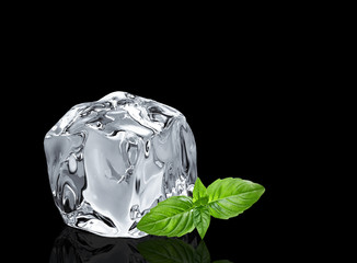 Melted clear ice cube with lime and basil leaf isolated on black background	