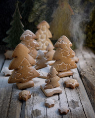 Stamped gingerbread cookies in the shape of Christmas trees on an old wooden table. Decorative vintage wooden Christmas tree toys. Christmas and New year
