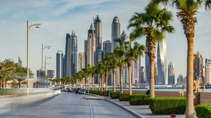 Waterfront promenade on the Palm Jumeirah with palms at road timelapse. Dubai, United Arab Emirates