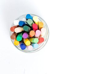 Oil pestel in a glass cup on a white table.