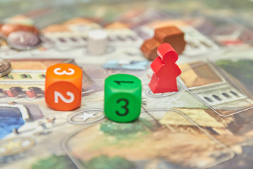 themed Board games. colorful play figures with dice on Board. vertical view of the Board game close-up.