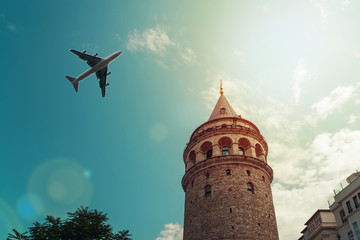 Obraz premium Airplane flies over the Galata tower, Istanbul, Turkey. Travel concept