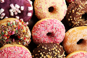 assorted donuts with chocolate frosted, pink glazed and sprinkles donuts