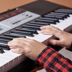 Obraz premium Hard-working Caucusing boy is having is music lesson. He is playing piano. Close-view.