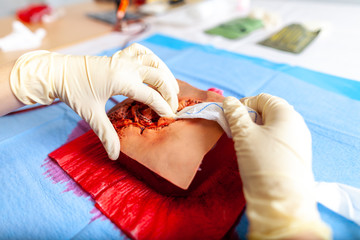 German military medic practice bleeding control on a wound dummy