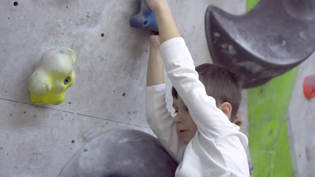 Boy climbing indoor rock wall