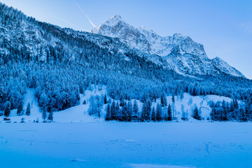 Blick auf den zugefrorenen Ferchensee und den zugeschneiten Alpen in Mittenwald 