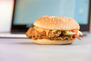 The rhythm of life. Fast food closeup in the form of a Hamburger against the backdrop of the working environment. 