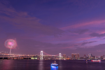 Obraz premium Rainbow bridge in Tokyo at night with fireworks.