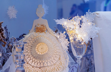 Statuette of a girl in a lace dress on a blue background.