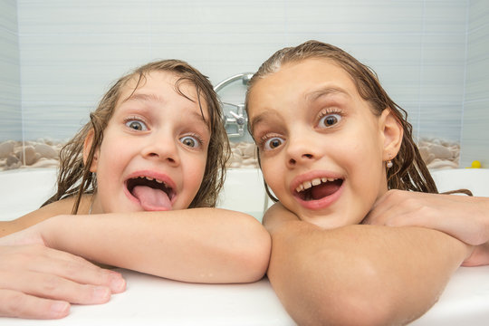 Two funny girls bathing in the bath