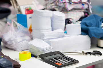 accessories for pattern clothes are on the table. Calculator, scissors, cloth