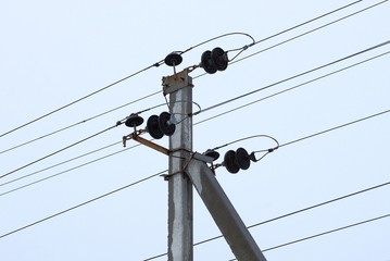 part of a gray concrete pillar with black wires against the sky