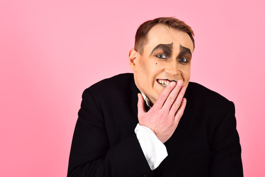Laughing face. Comedian performer giggling. Mime artist. Mime with face paint. Man with mime makeup. Theatre actor miming. Stage actor miming. Theatrical performance art and pantomime. Comedy