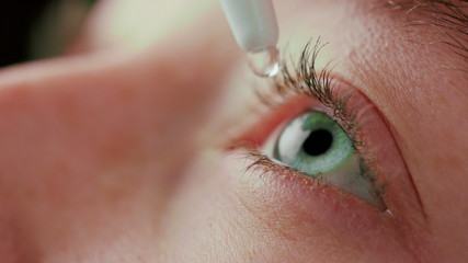 macro close up eye using eyedrops liquid medicine healthy eyesight clarity concept