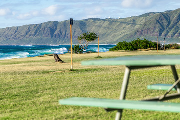 Picnic table and the beautiful landscape of the Hawaiian mountains of volcanic formation on the west side of the island of Oahu in Hawaii