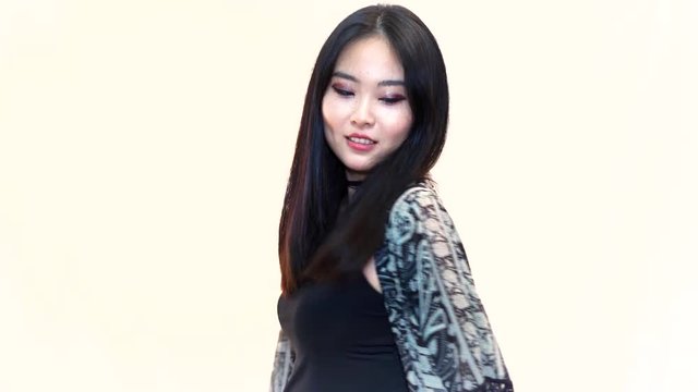 Asian woman posing and looking over shoulder.Young Chinese girl posing and turning on isolated background. Beautiful girl nervous in front of the camera.