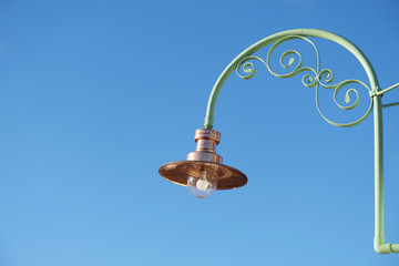 Copper light lantern lamp and large glass bulb against blue sky victorian vintage style