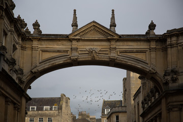 Obraz premium Arch over a English street with flock of birds in the sky