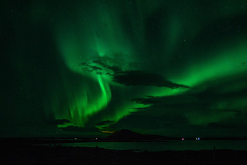Winter scenic landscape night view of  Aurora Borealis/Northern lights dancing on the clear sky full of stars above lake Myvatn, north Iceland Beautiful winter wonderland/fairytale background scene. 