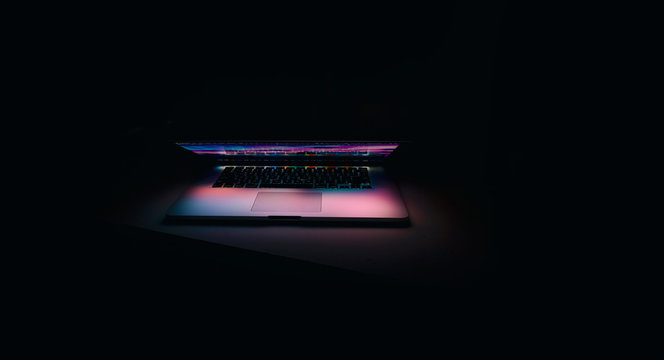 Open Laptop with Colourful Glow II on a black background