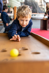 Child concentrated while playing with a medieval ball game.