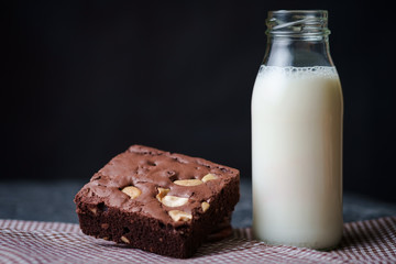 Brownies with bottle of milk on the black background
