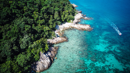 Amazing aerial drone view of a boat approaching Perhentian Island, a tropical paradise in Malaysia