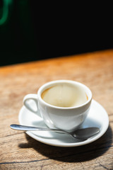 Dirty coffee cup on the wooden table with natural light in the cafe.