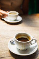 Dirty coffee cup on the wooden table with natural light in the cafe.