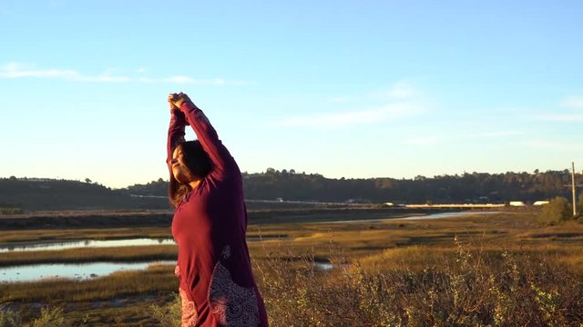 Young woman doing yoga meditation prayer pose in the forest