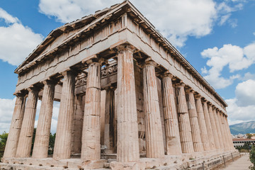 Obraz premium Temple of Hephaestus in Agora close-up, Athens, Greece. It is one of the main landmarks of Athens. Front view of the ancient Greek Temple of Hephaestus in summer. Historical sunny postcard of Athens.