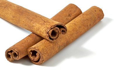 Cinnamon sticks or rolls with powder pile isolated on white background - top view