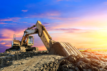 Excavator work on construction site at sunset