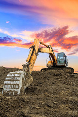 Excavator work on construction site at sunset
