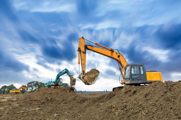 Obraz premium Excavator working on construction site in cloudy day