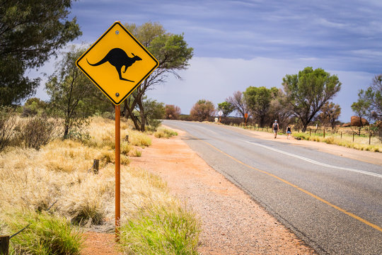A typical road and Australian road sign of kangaroos crossing, taken at Uluru or Ayers Rock in the outback desert of Australia