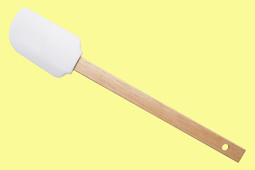 Kitchen spatula silicone with wooden handle on yellow background. Isolated.