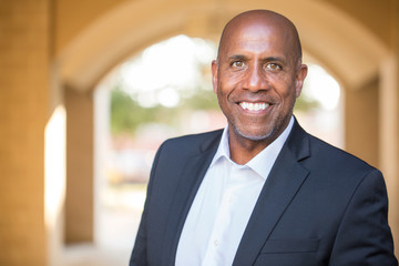 Mature African American casually dressed businessman smiling.